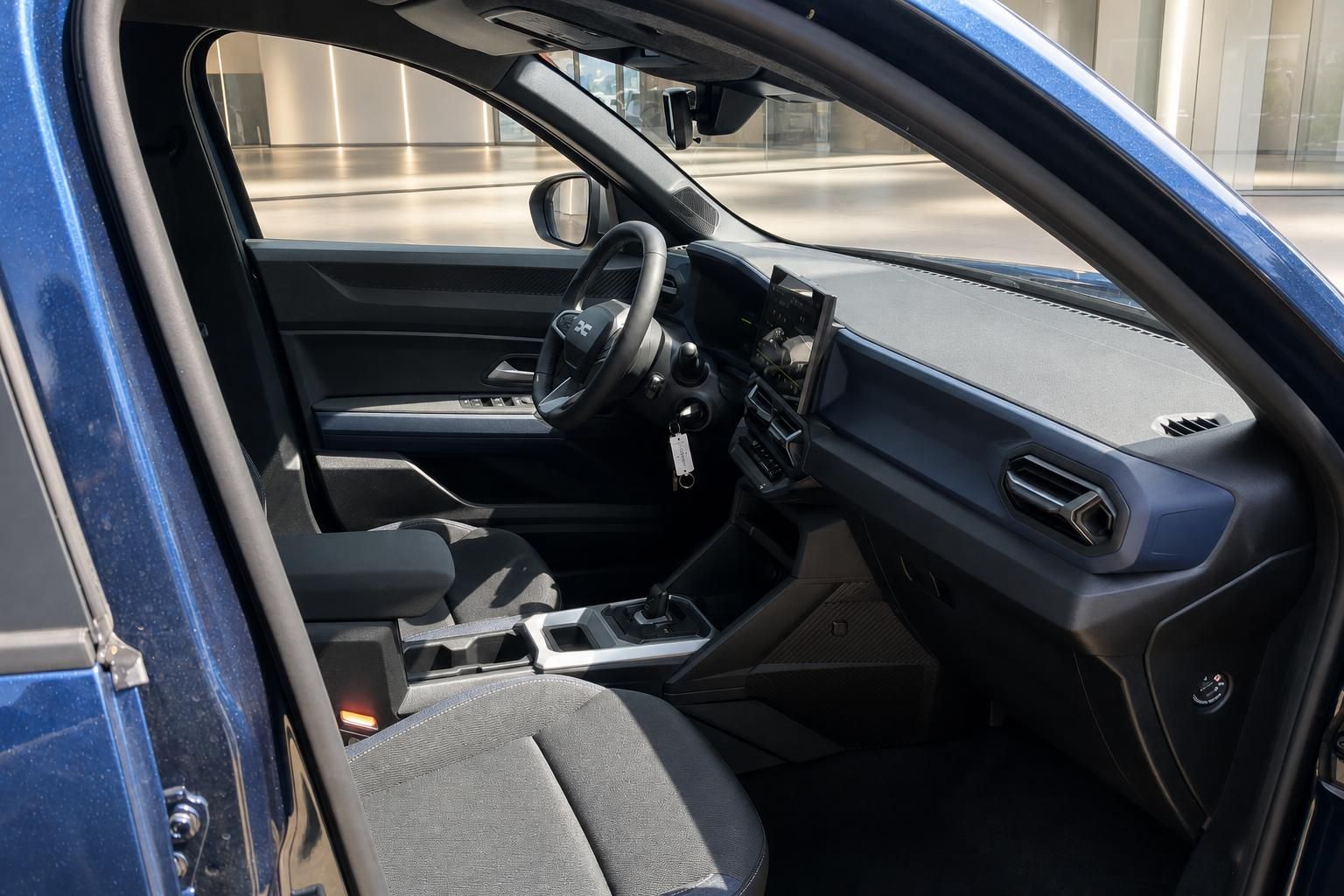 Dacia Innenraum Fahrerseite in Blau mit Lenkrad, Mittelkonsole und Touchscreen