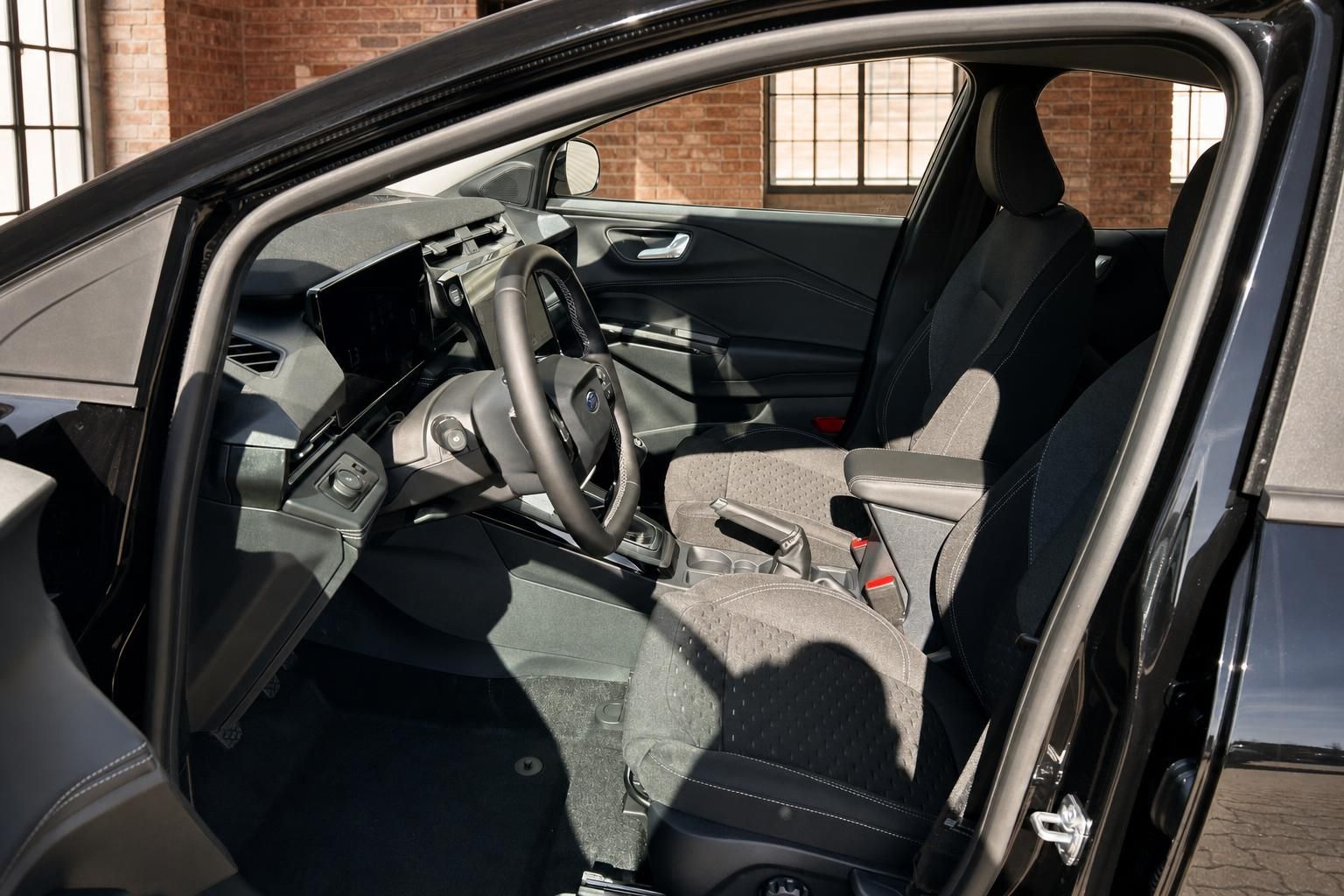 Ford Puma Innenraum Fahrerseite – Cockpit mit Touchscreen, Lenkrad und Vordersitze in Stoff
