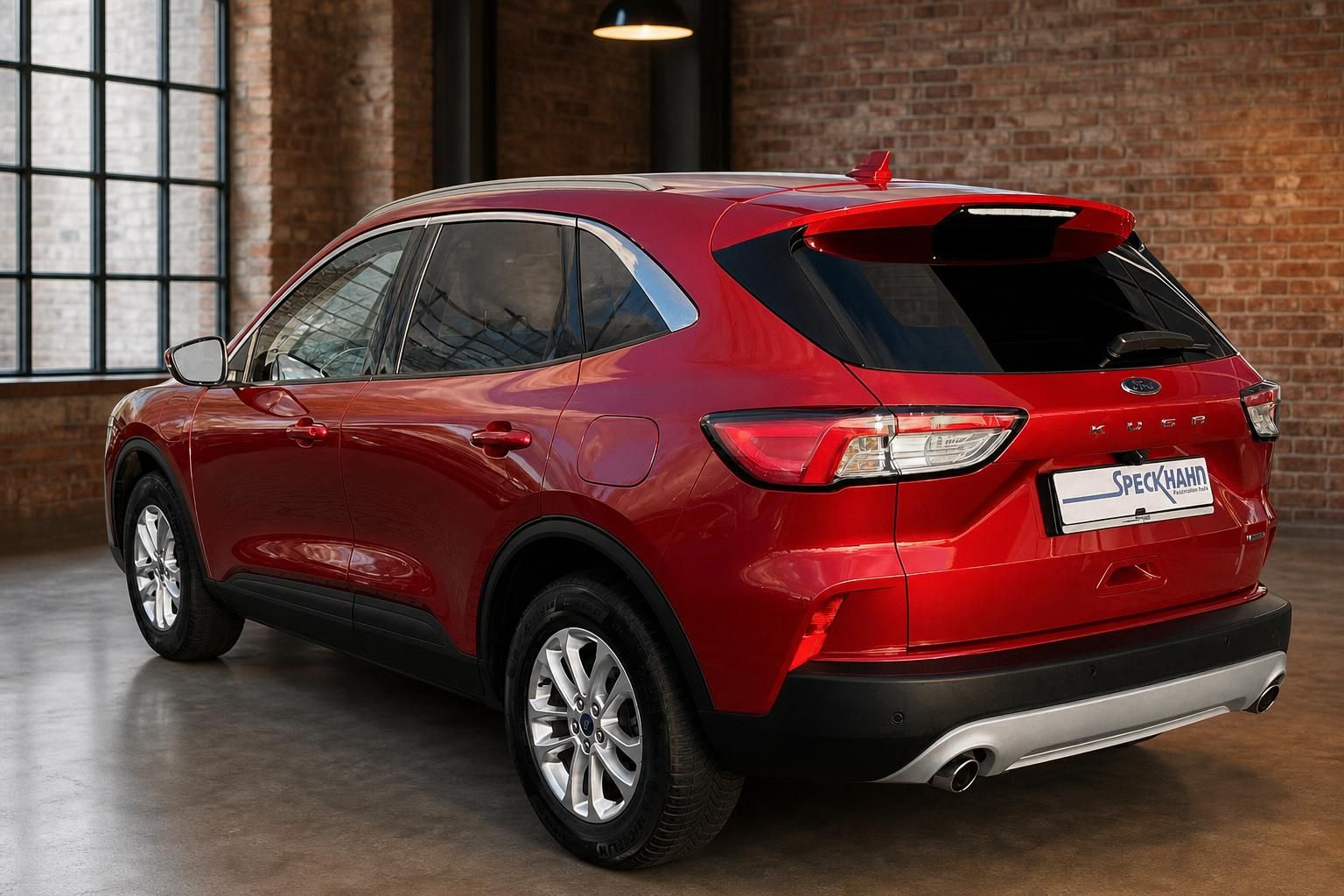 Ford Kuga rot Heckansicht seitlich in moderner Halle mit Backsteinwand