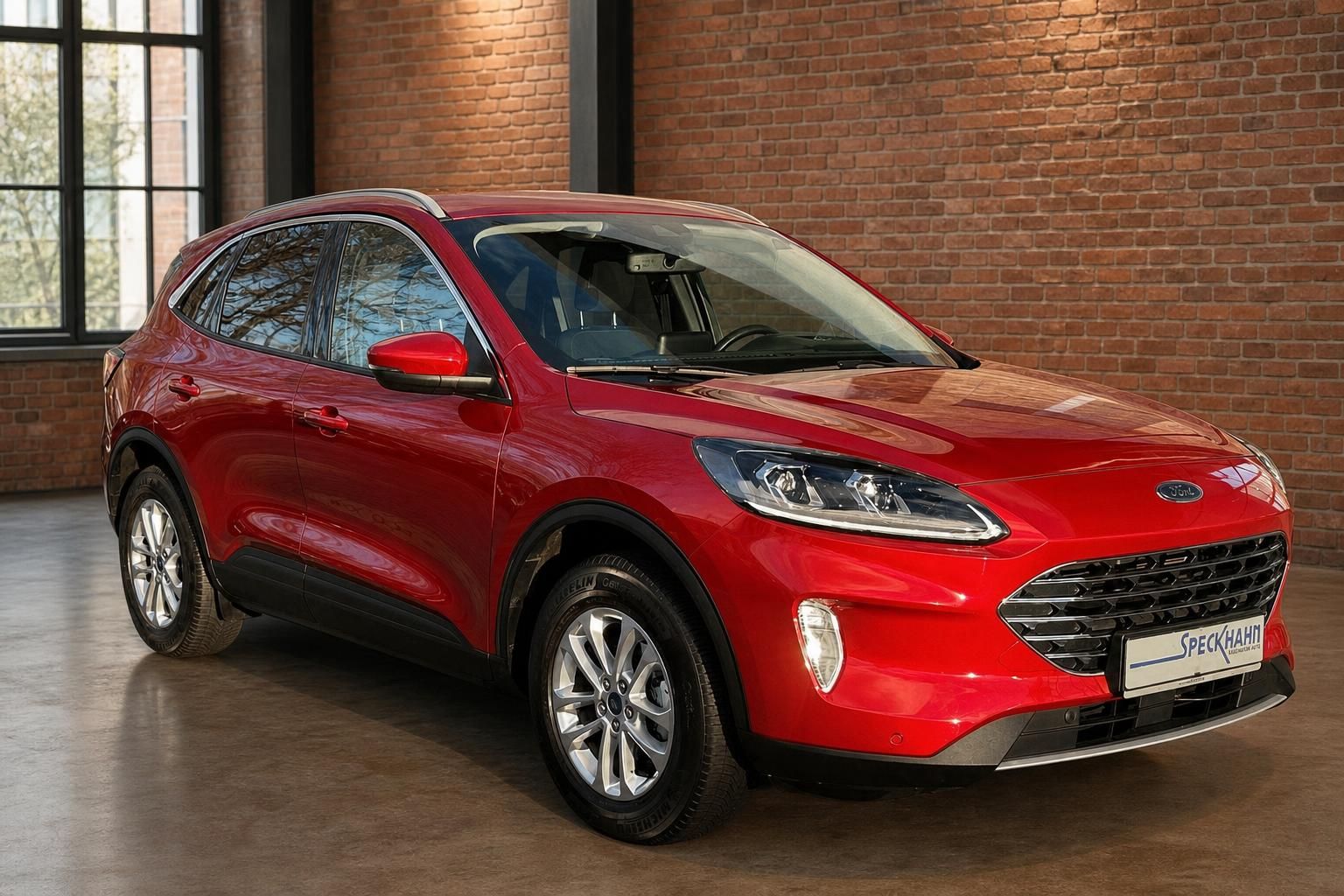 Ford Kuga rot Frontansicht schraeg vor Backsteinwand im Autohaus