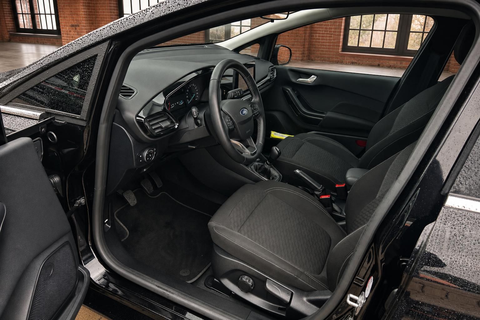 Ford Fiesta Innenraum schwarze Stoffsitze Lenkrad Schaltgetriebe und Armaturenbrett Fahrerseite