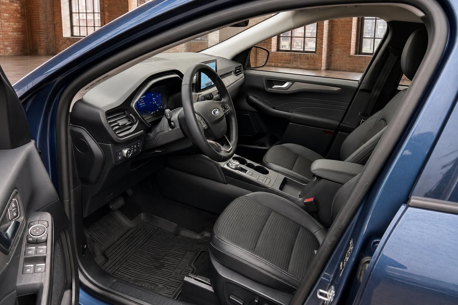 Ford Kuga Innenraum Fahrerseite mit Cockpit, Lenkrad und schwarzen Sitzen