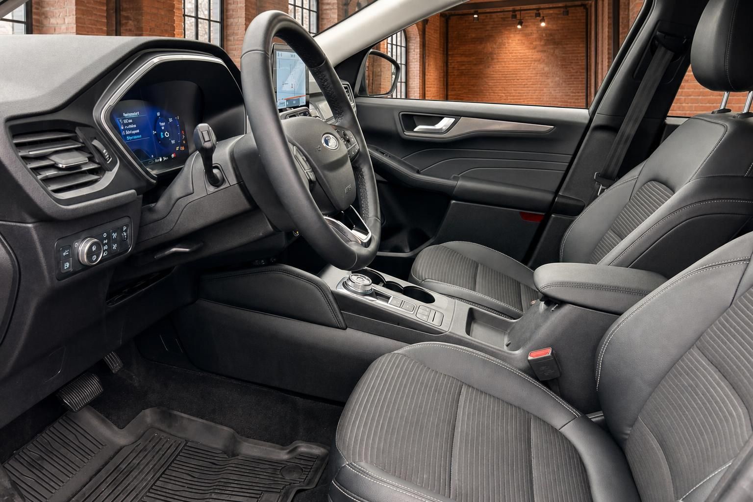 Ford Innenraum Fahrerseite mit Lenkrad, Automatikgetriebe und schwarzen Stoffsitzen
