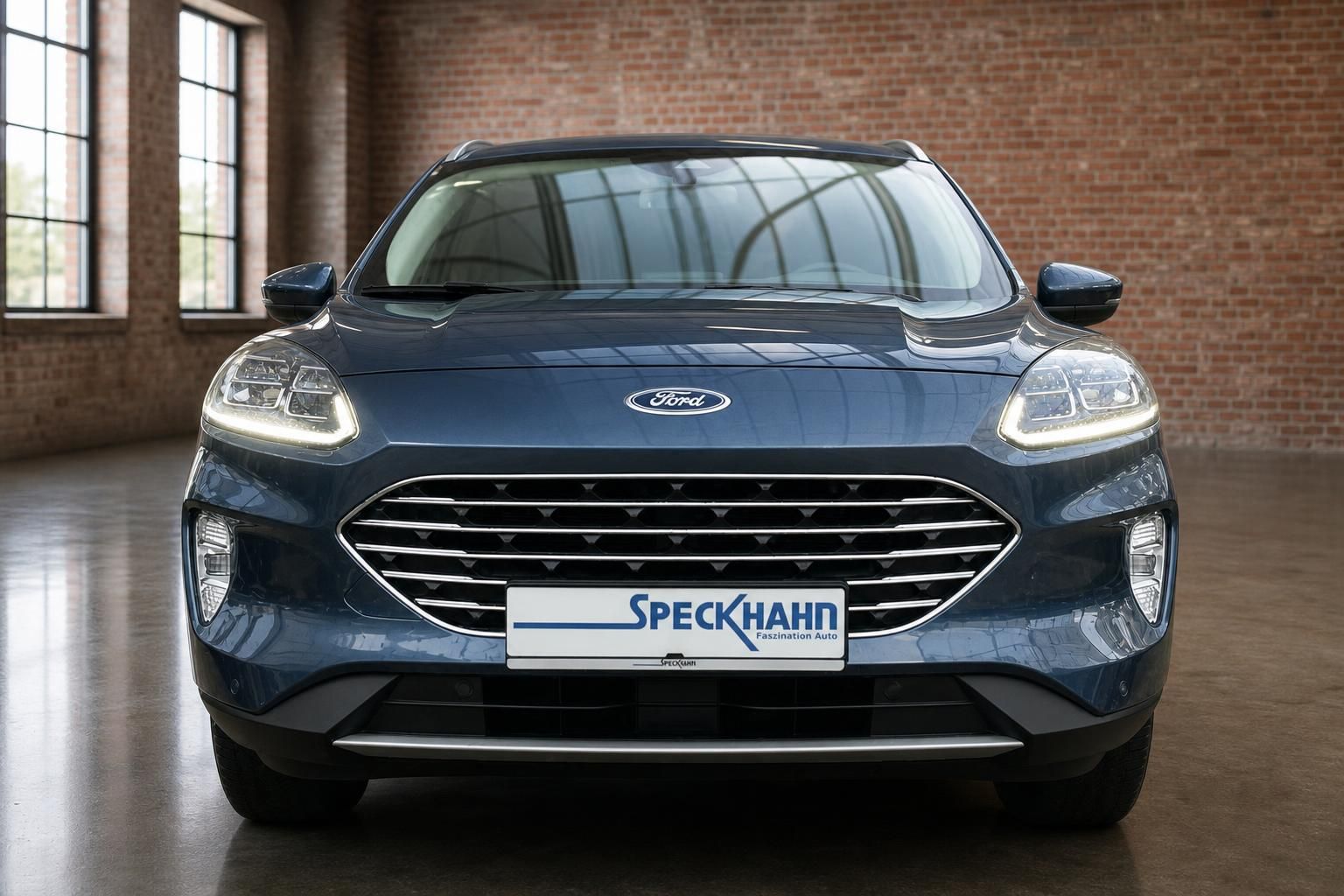 Ford Kuga Frontansicht blau mit Speckhahn Händlerschild im Showroom