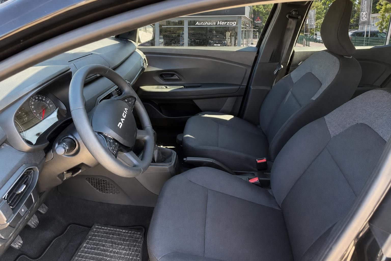 Dacia Innenraum mit Vordersitzen, Lenkrad und Schaltung im Detail