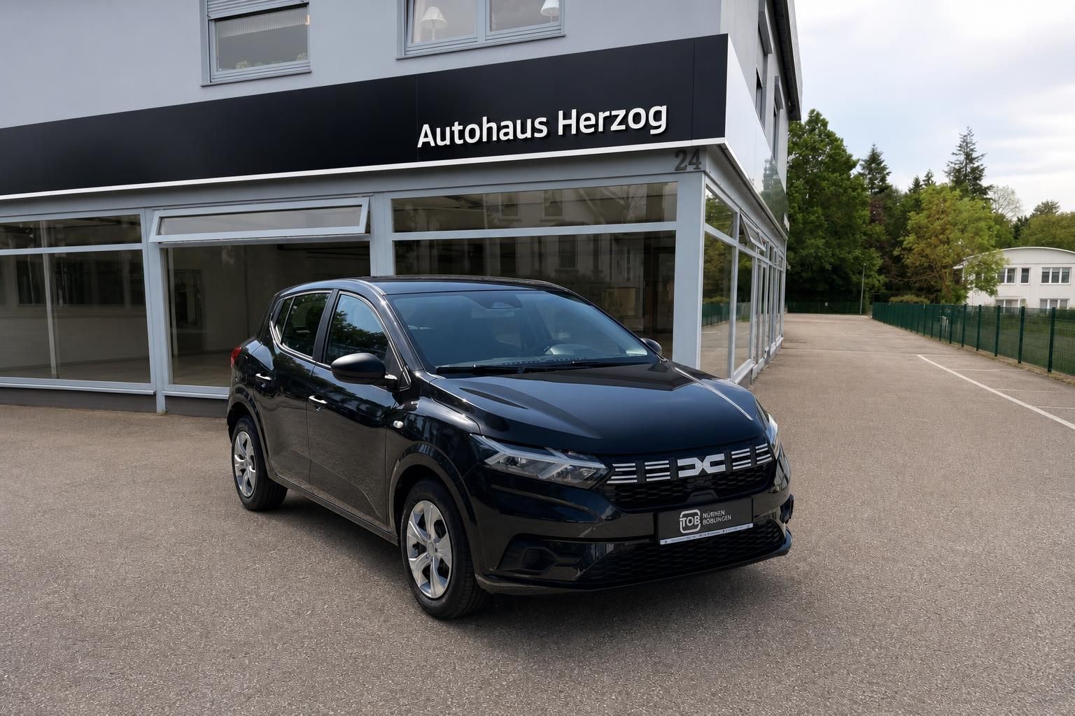 Dacia Sandero schwarz Frontansicht vor Autohaus Herzog