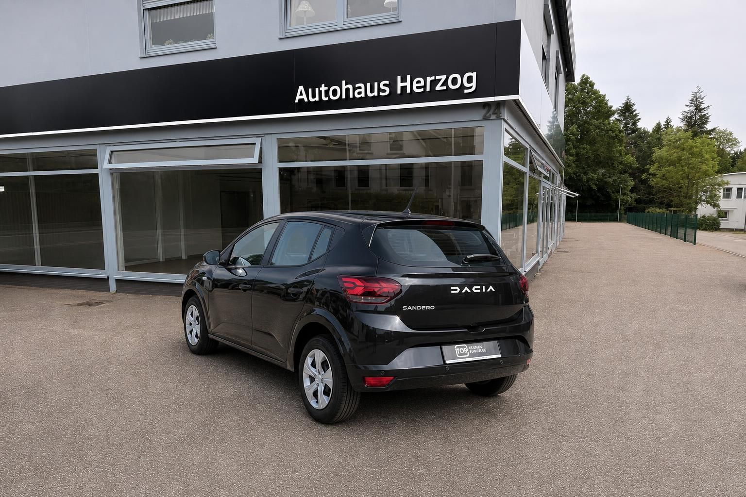 Dacia Sandero schwarz Heckansicht vor Autohaus Herzog
