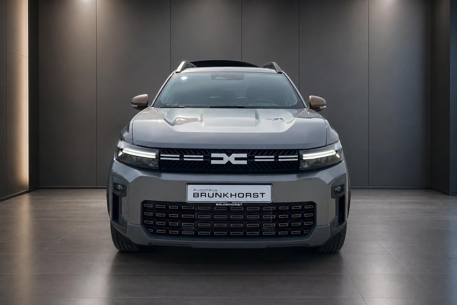 Dacia Bigster SUV Frontansicht - graues Fahrzeug mit charakteristischem Kühlergrill im Autohaus