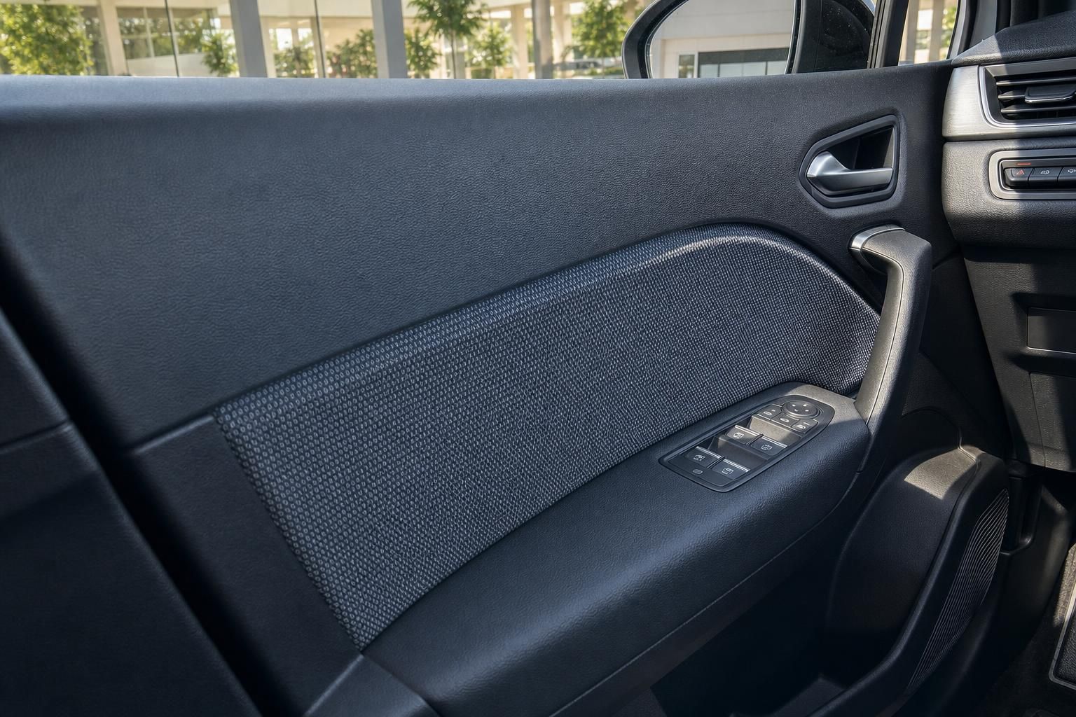 Fahrzeugtürverkleidung mit Fensterheberschaltern und dunkler Textil-Optik