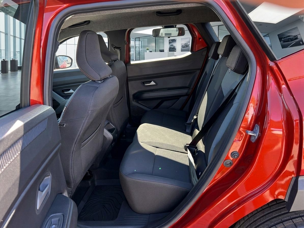 Rücksitzbereich eines roten Dacia mit grauen Polstern und Sicherheitsgurten