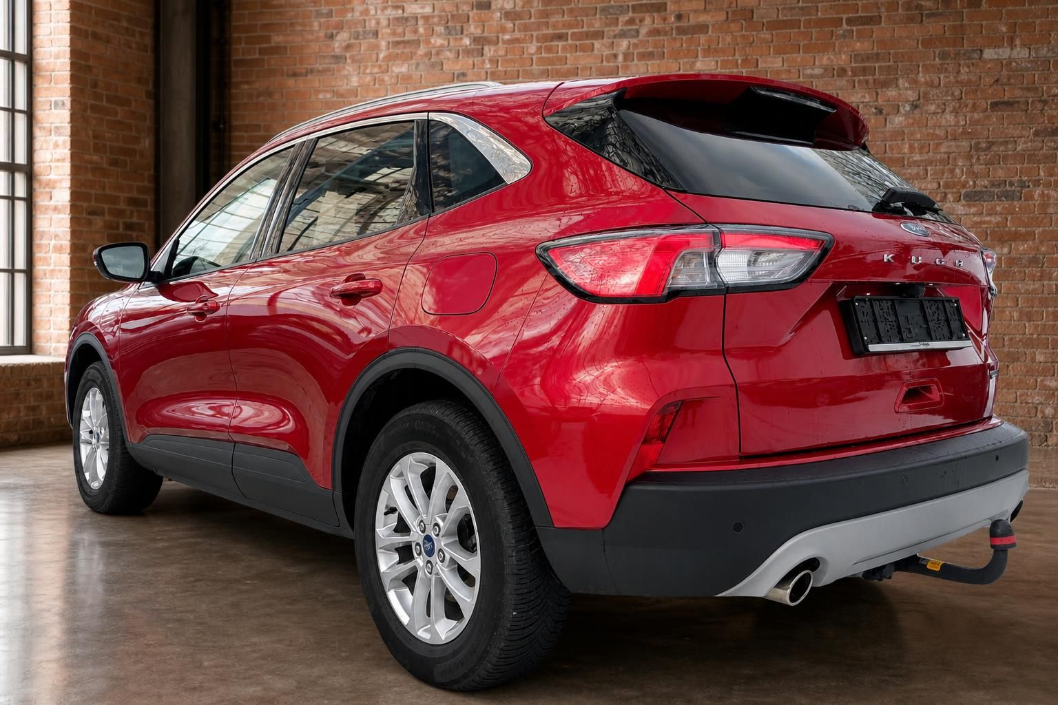 Ford Kuga rot, Heck-Seitenansicht in Backsteinhalle
