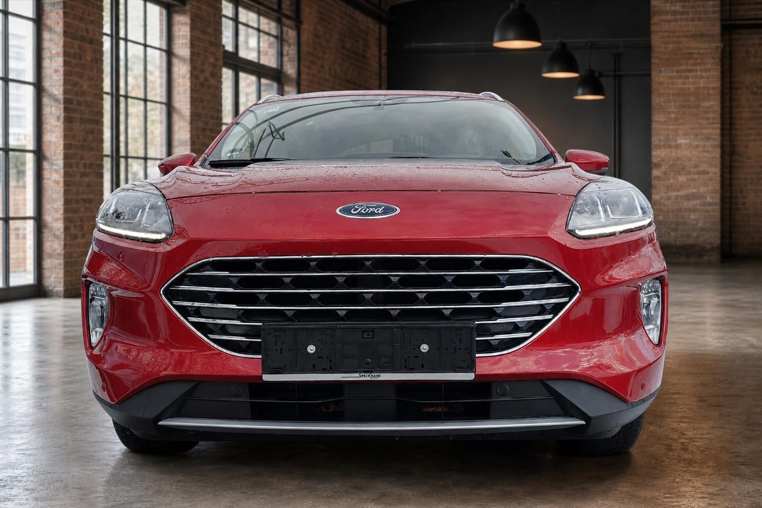 Ford Kuga in Rot, Frontansicht mit Kuehlergrill in modernem Showroom