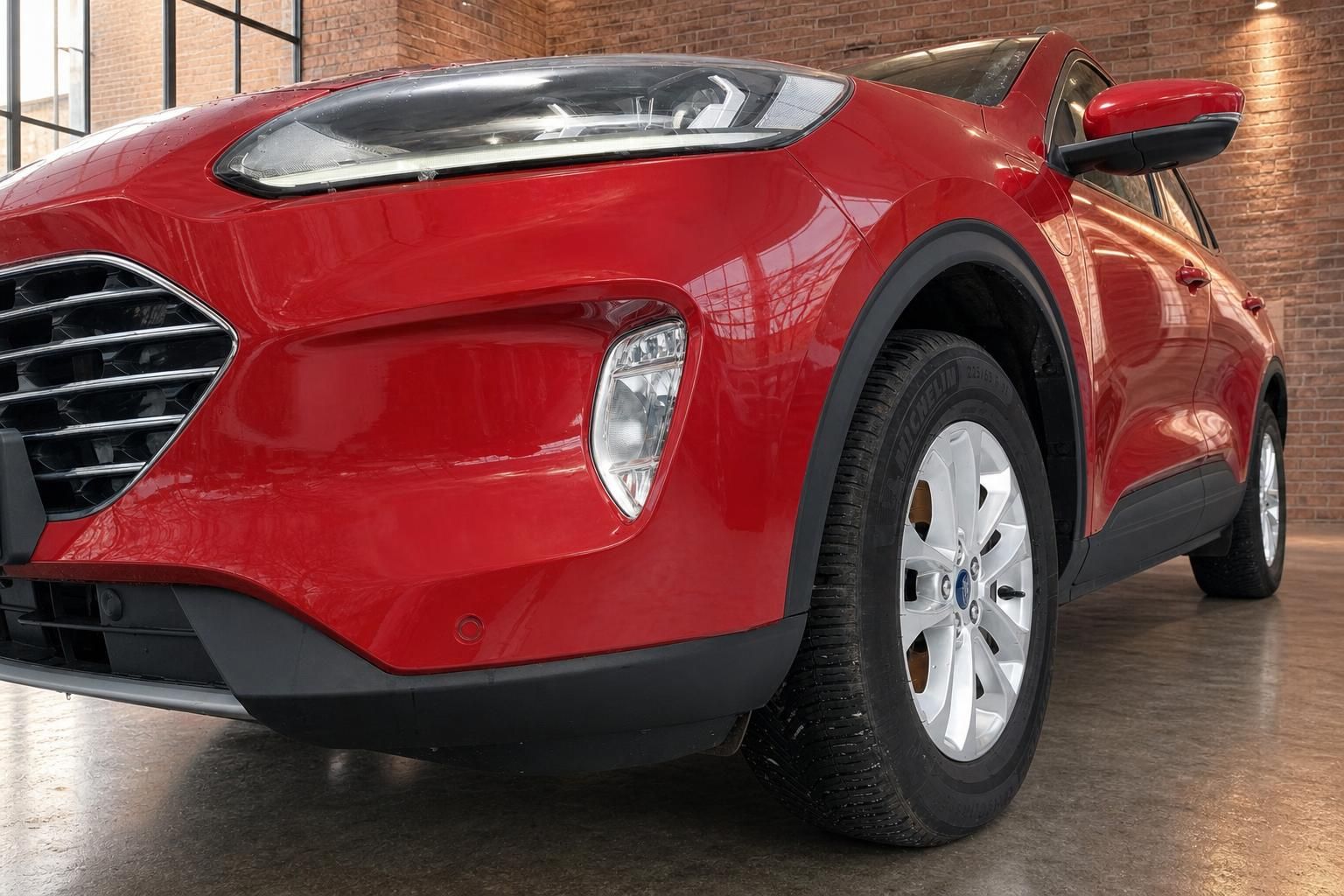 Ford Kuga rot Seitenansicht Detail Scheinwerfer und Felge im Showroom