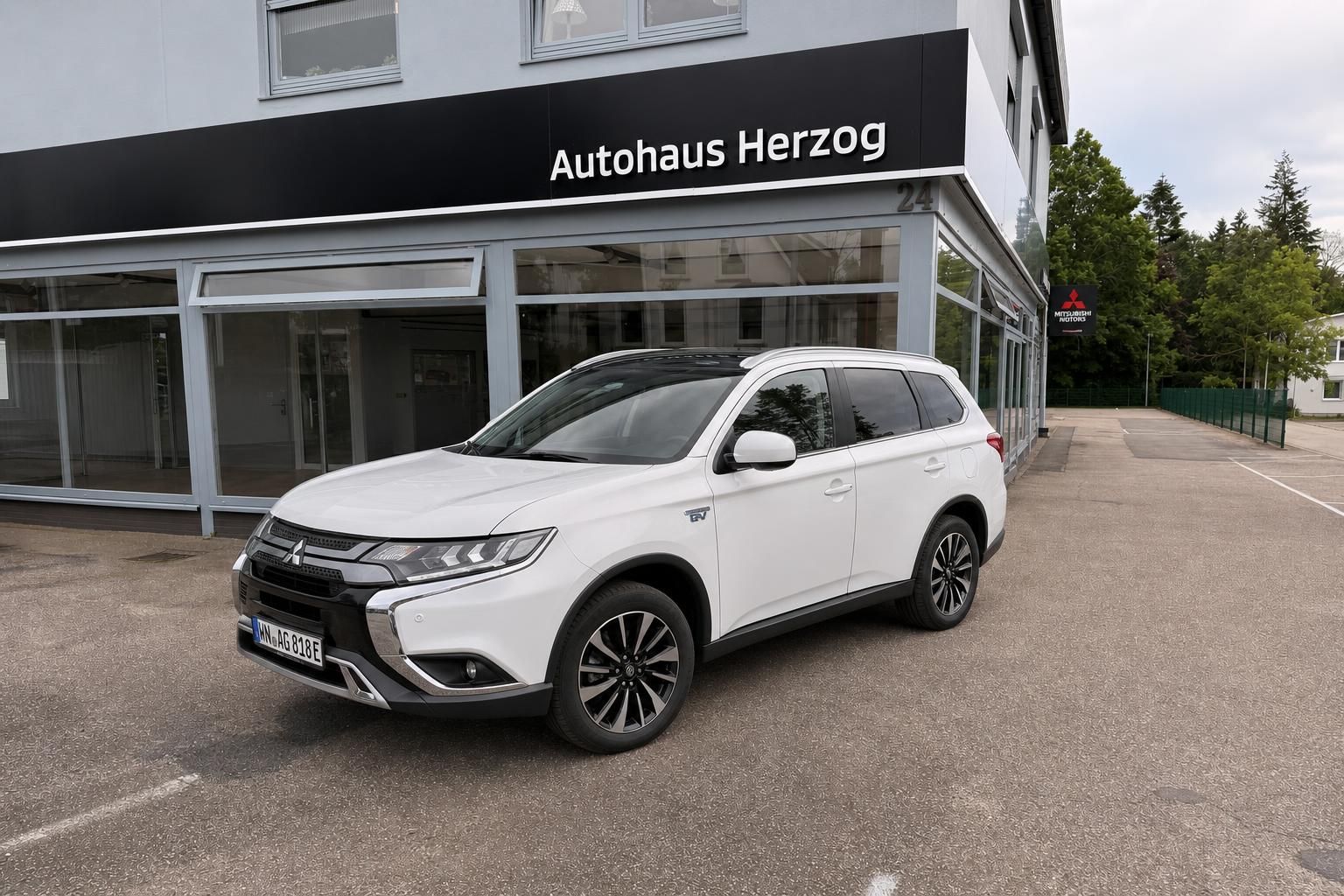 Mitsubishi Outlander PHEV weiß vor dem Autohaus Herzog geparkt