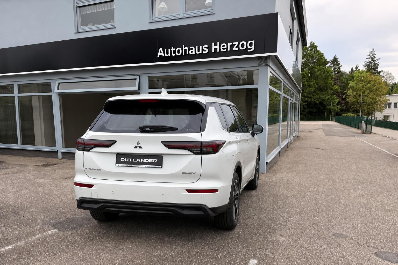 Mitsubishi Outlander PHEV weiß Heckansicht seitlich vor Autohaus