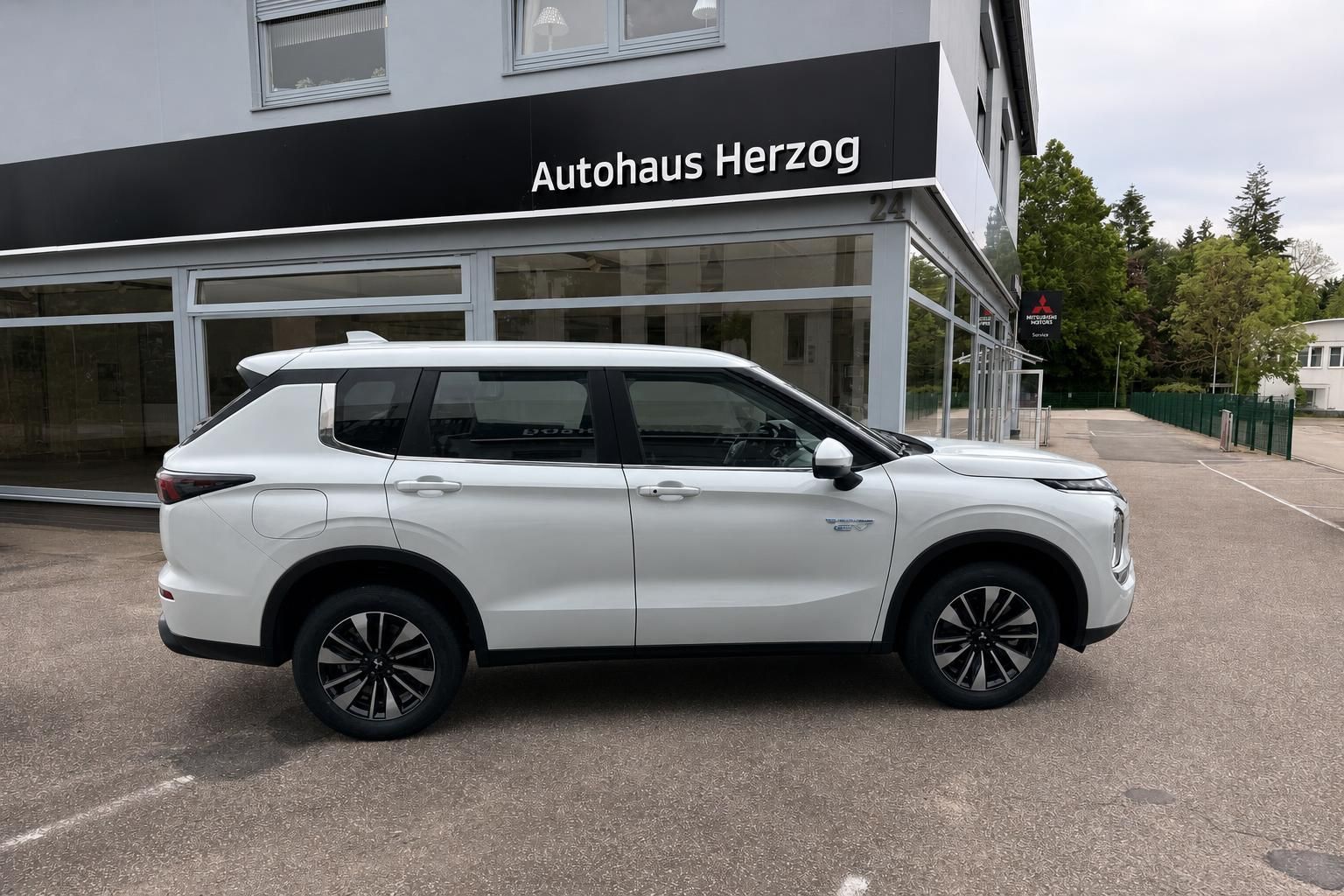 Mitsubishi Outlander PHEV weiß Seitenansicht beim Autohändler