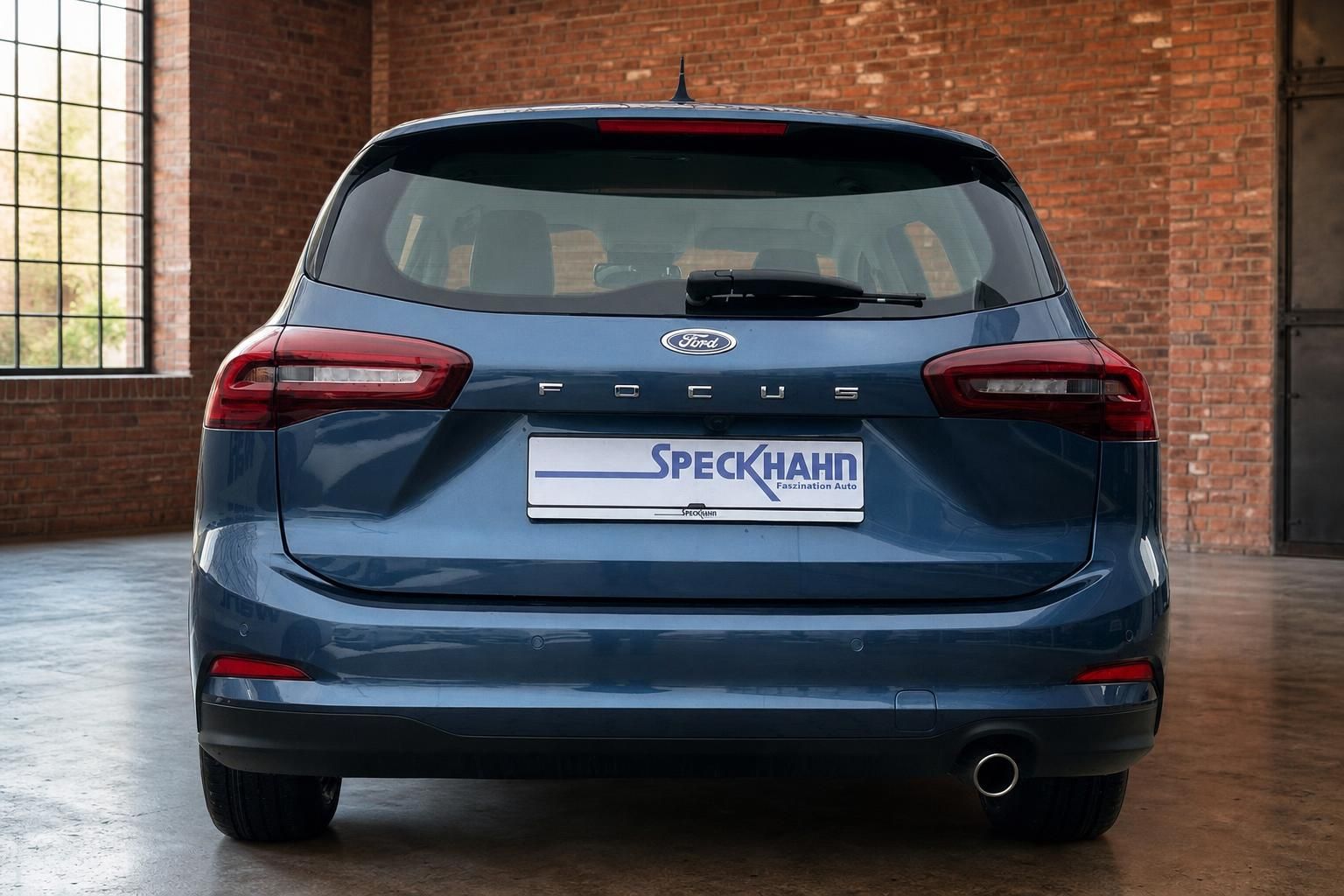Ford Focus Turnier blau Heckansicht in Studio mit Ziegelwand