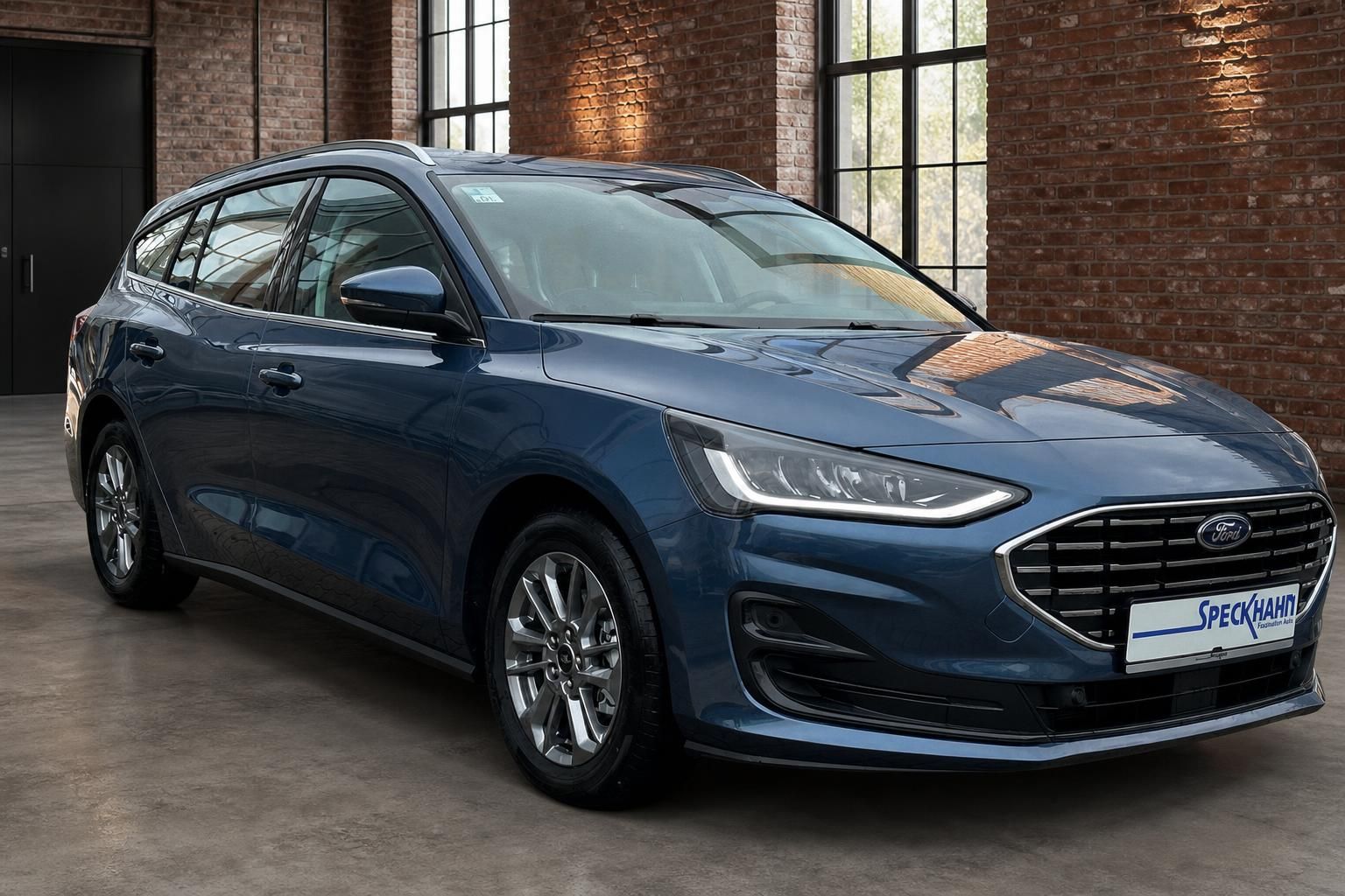 Ford Focus Turnier blau Frontansicht schraeg an Ziegelwand