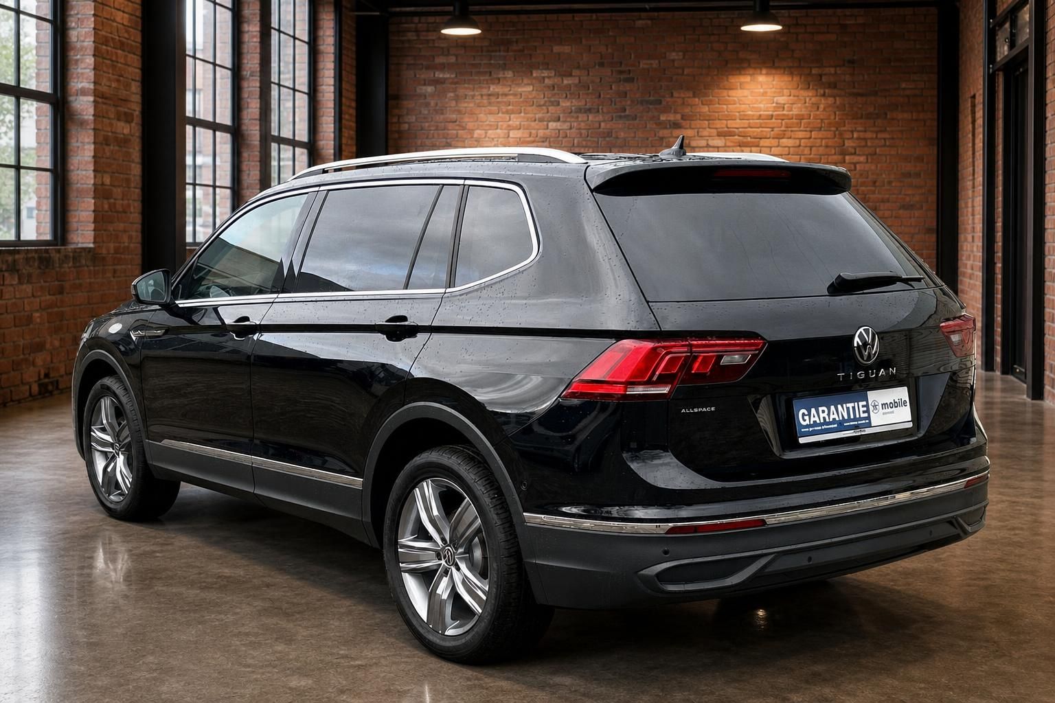 VW Tiguan Allspace schwarz Heckansicht seitlich in Industriehalle
