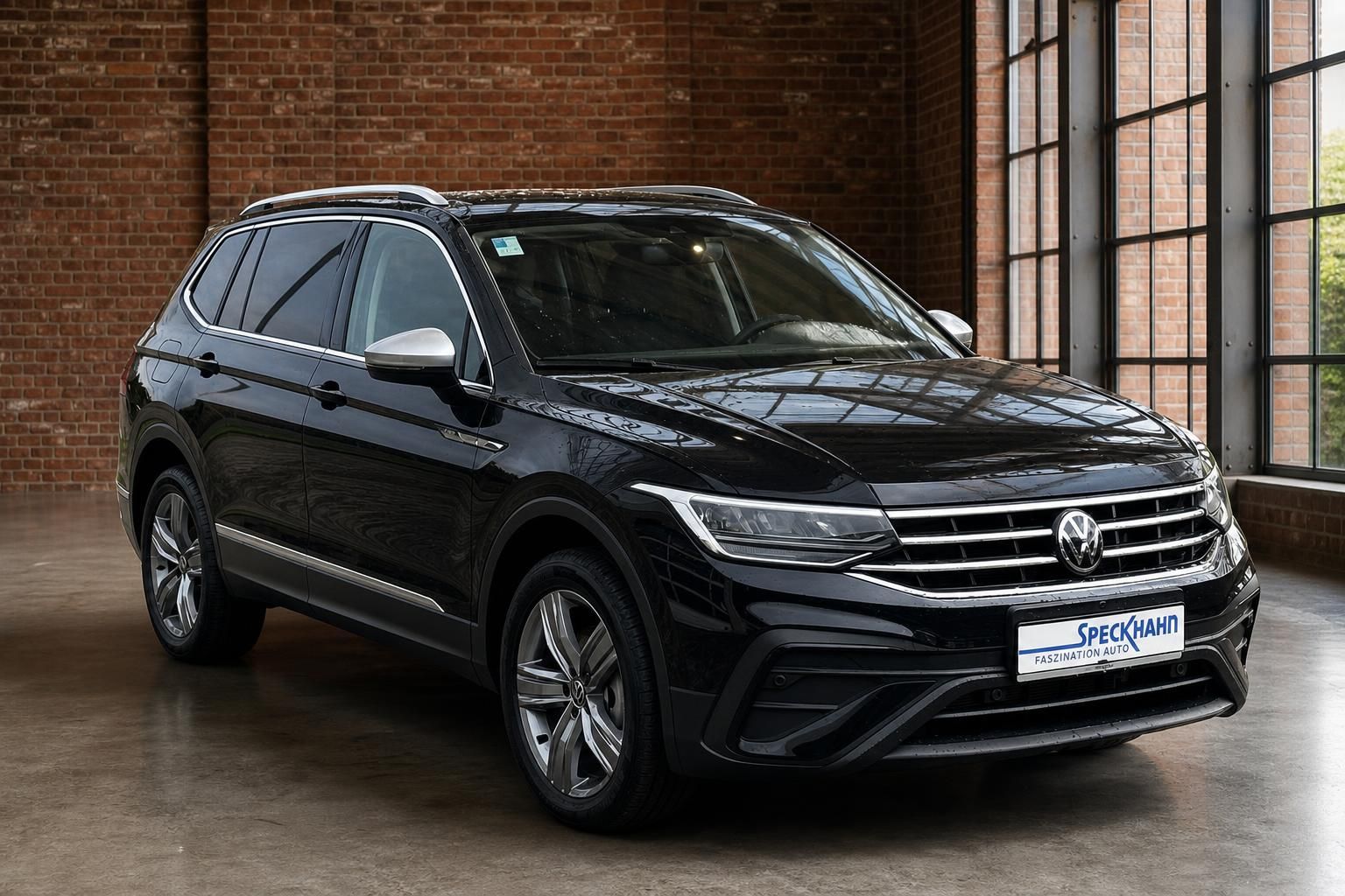 VW Tiguan schwarz Frontansicht schraeg in Industriehalle mit Fenstern