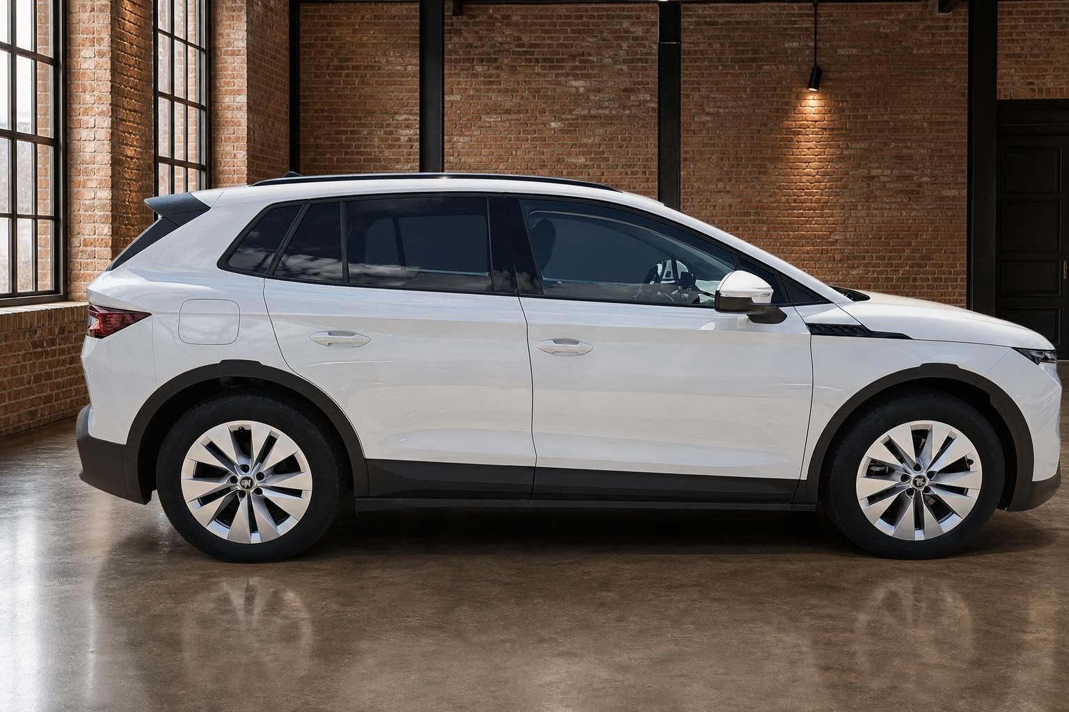 Škoda Elroq weiß, Seitenansicht in Loft mit Backsteinwand