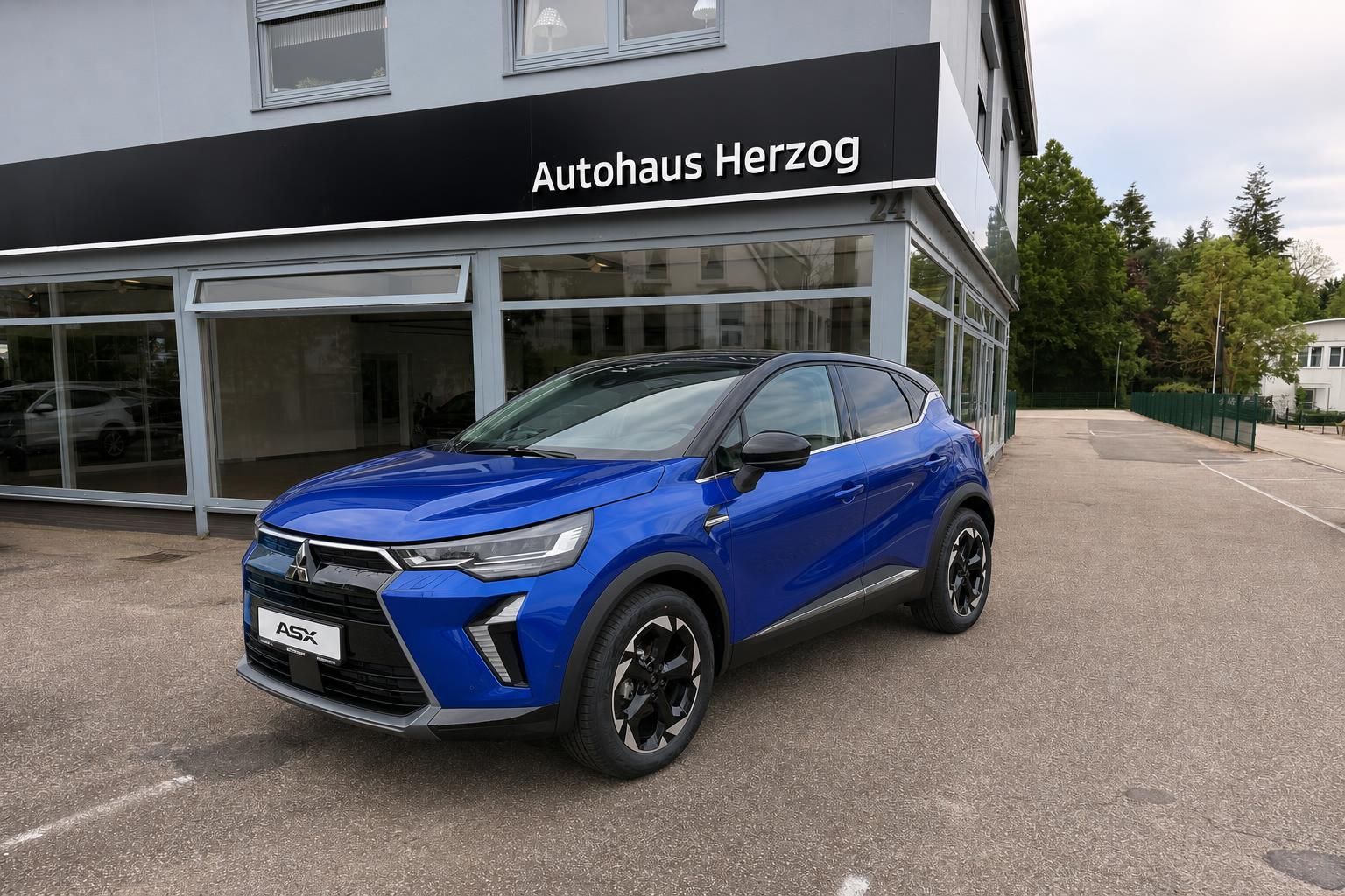 Blauer Mitsubishi ASX SUV vor Autohaus Herzog Showroom in Dreiviertelansicht