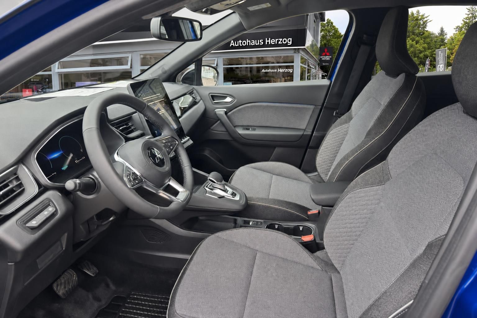 Mitsubishi SUV Innenraum mit grauem Stoff, Lenkrad und Vordersitze