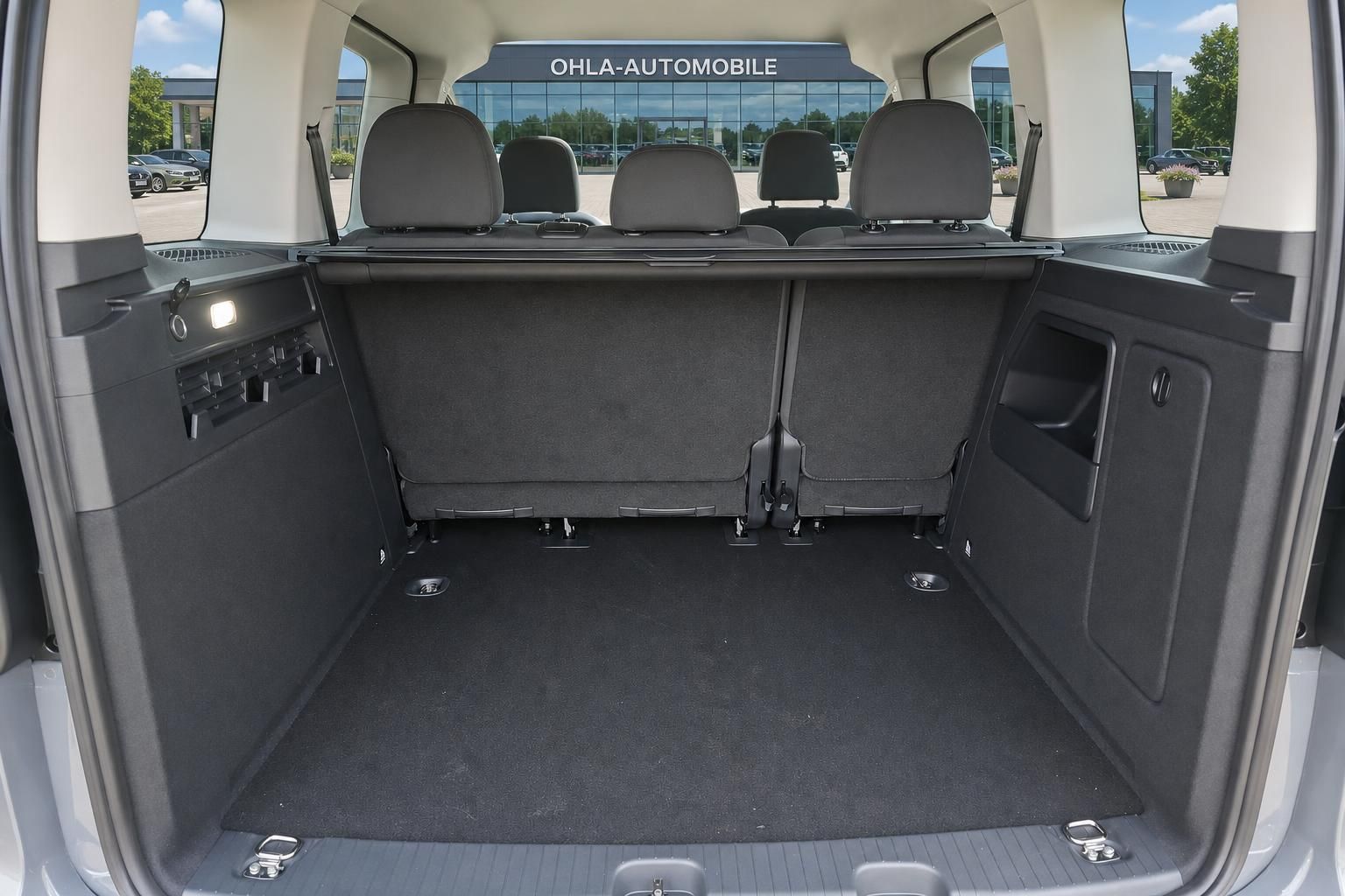 Kofferraum eines VW Vans mit umgeklappter Rückbank und großem Stauraum