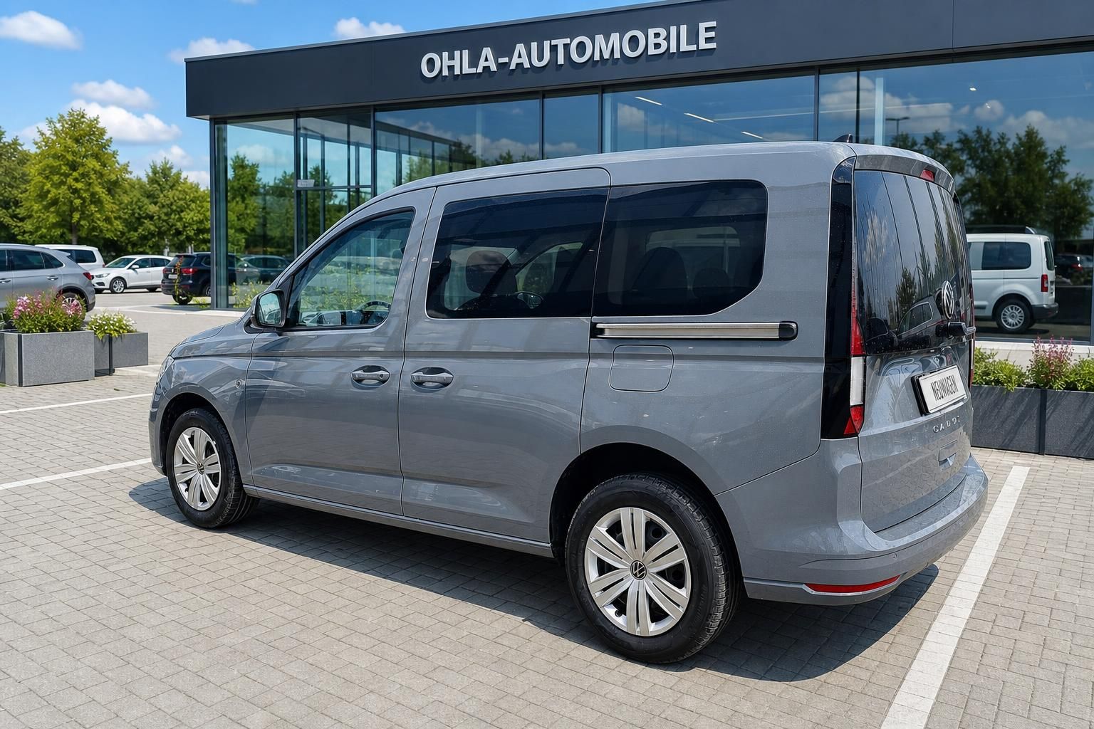 VW Caddy grau Heckansicht seitlich vor Autohaus Ohla