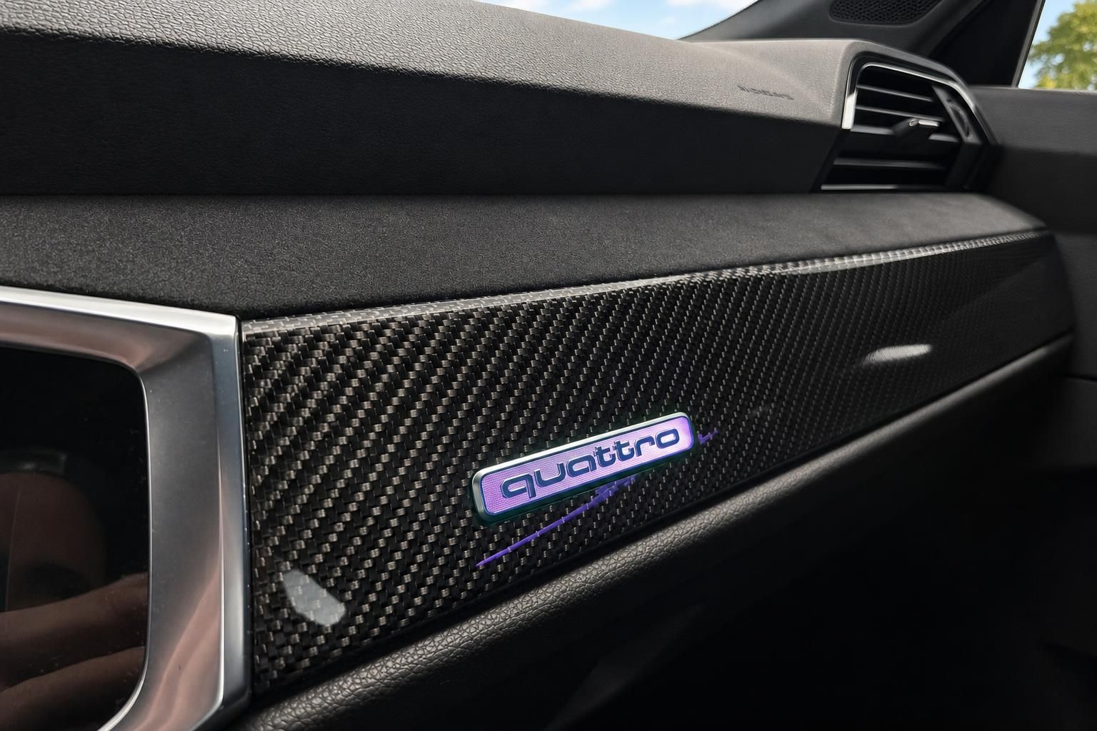 Audi quattro Schriftzug auf Carbon-Armaturenbrett im Innenraum