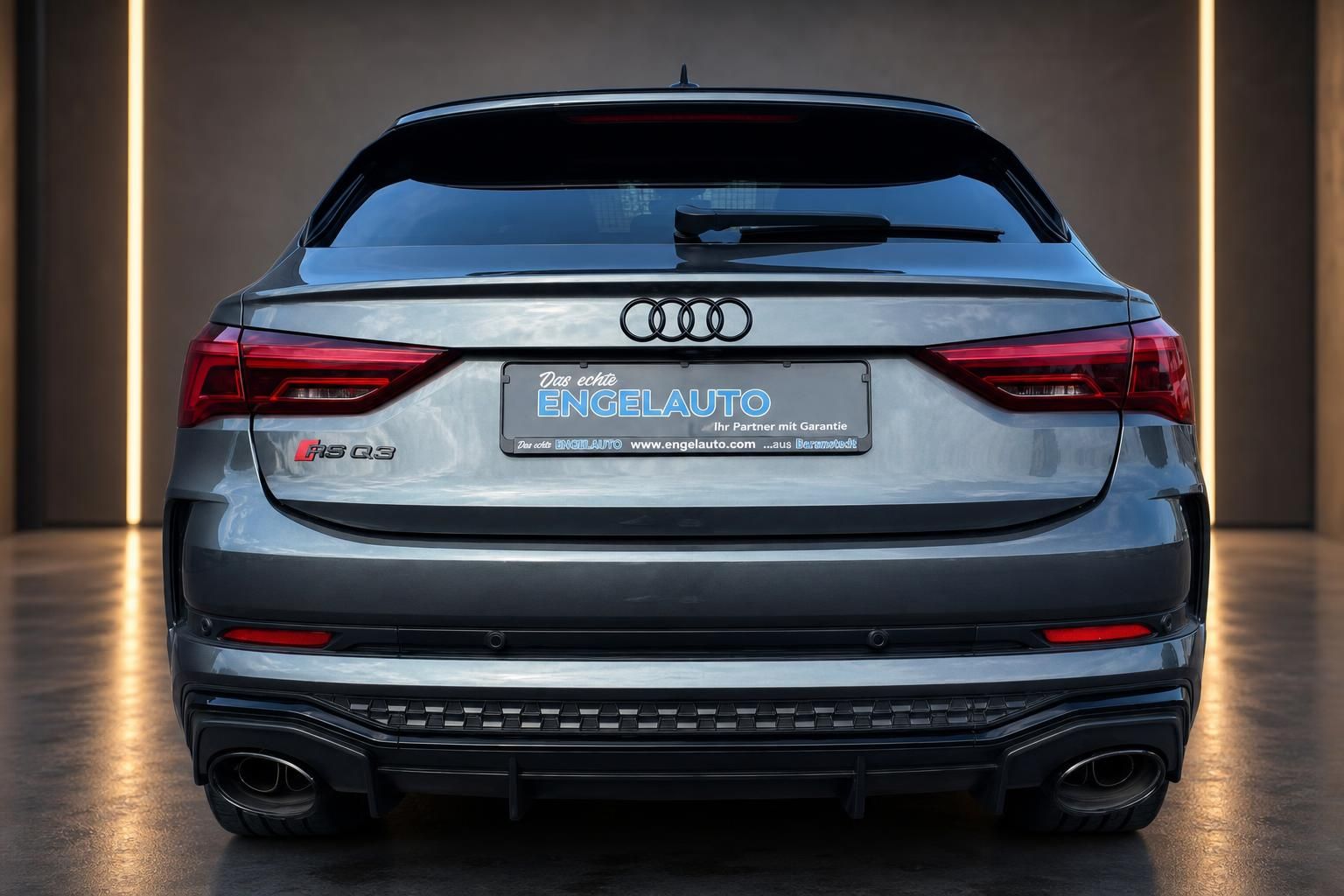 Audi RS Q3 Heckansicht in grau mit roten Rückleuchten und Sportauspuff
