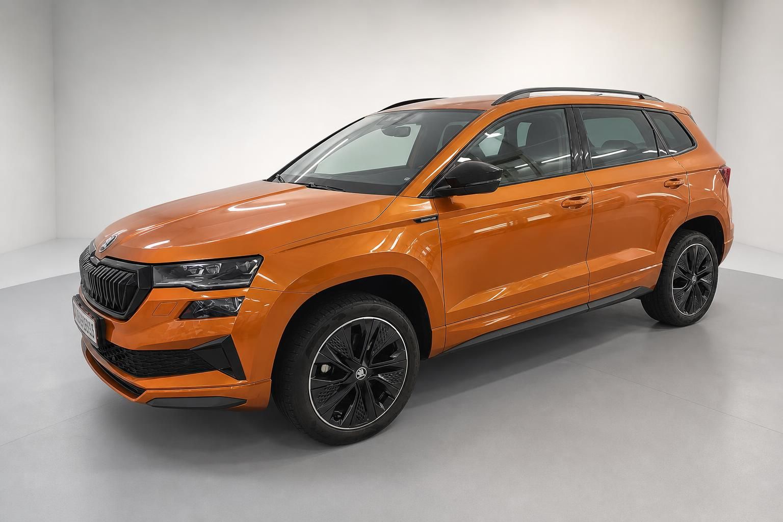 Skoda Karoq in Orange metallic, Frontansicht mit schwarzen Felgen im Studio