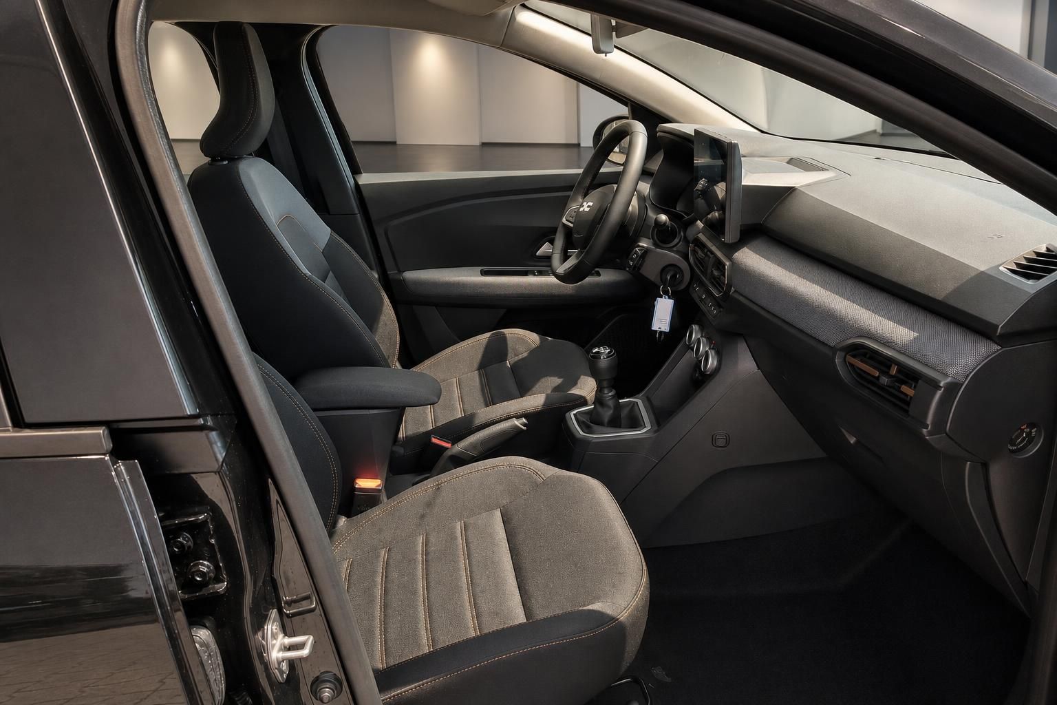 Dacia Innenraum Vordersitze und Armaturenbrett durch geoeffnete Tuer