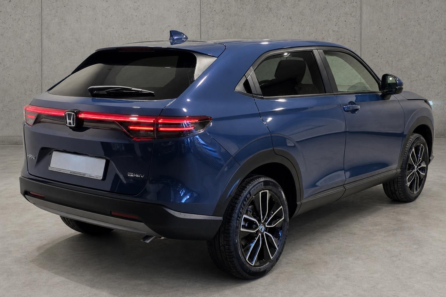 Honda HR-V e:HEV blau, Heckansicht seitlich im Studio