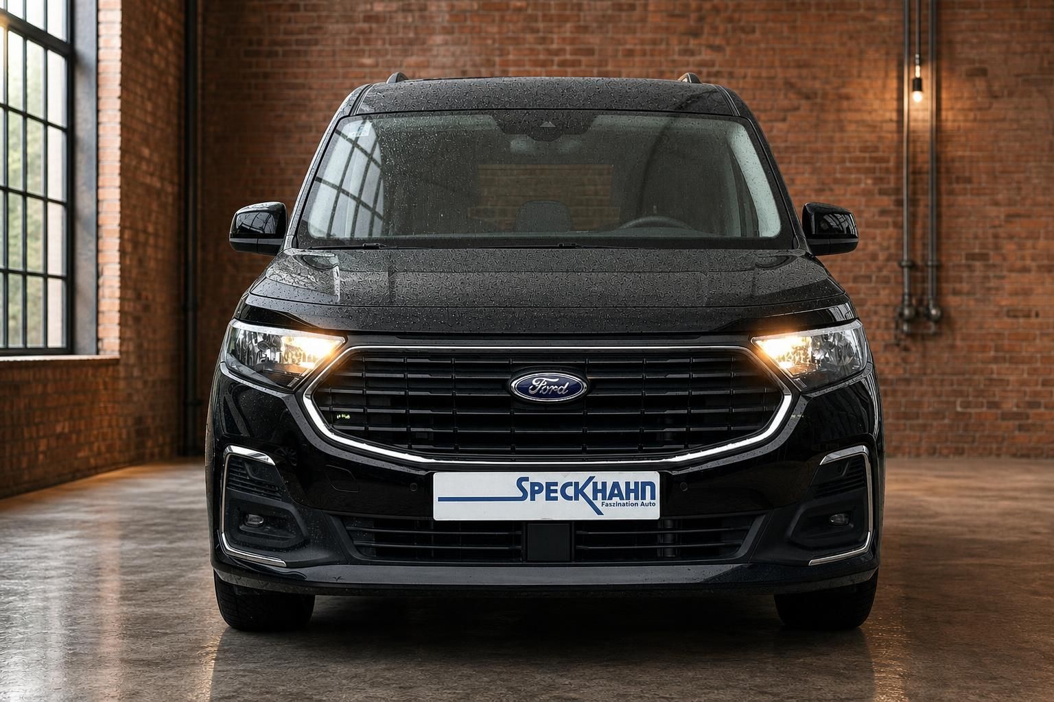 Ford Tourneo Connect schwarz Frontansicht mit eingeschalteten Scheinwerfern im Showroom