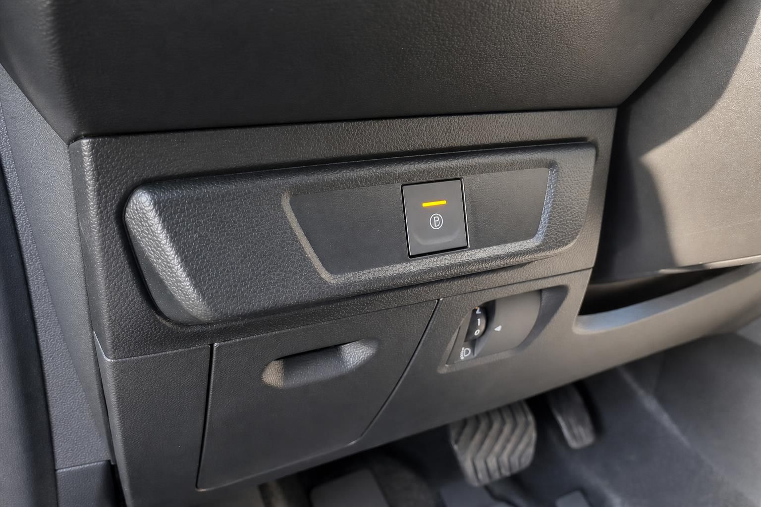 Innenraumdetail mit Bergabfahrhilfe-Taste und Lichtschalter im Auto