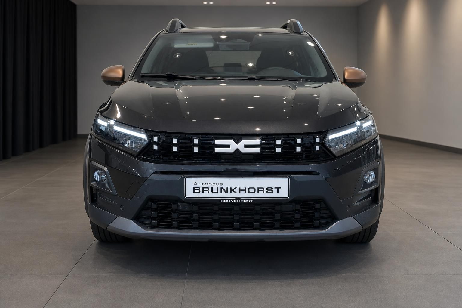 Dacia Sandero Stepway grau Frontansicht gerade mit LED-Tagfahrlicht im Showroom