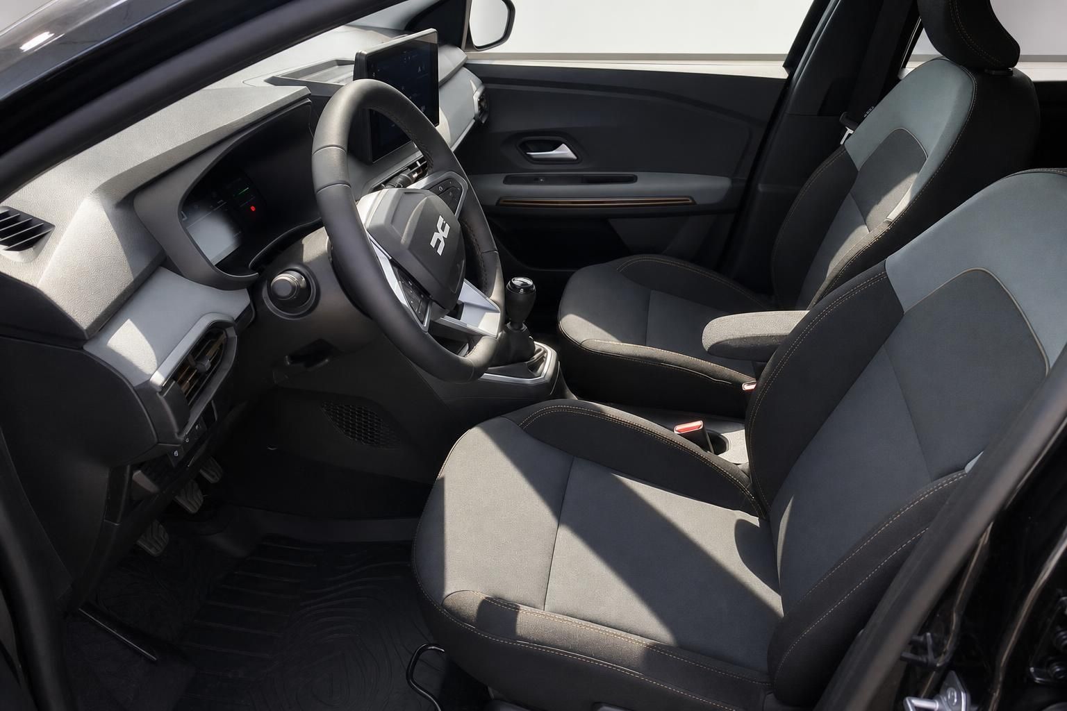 Dacia Sandero Innenraum mit Lenkrad, Schaltgetriebe und grauen Stoffsitzen – Fahrerseite