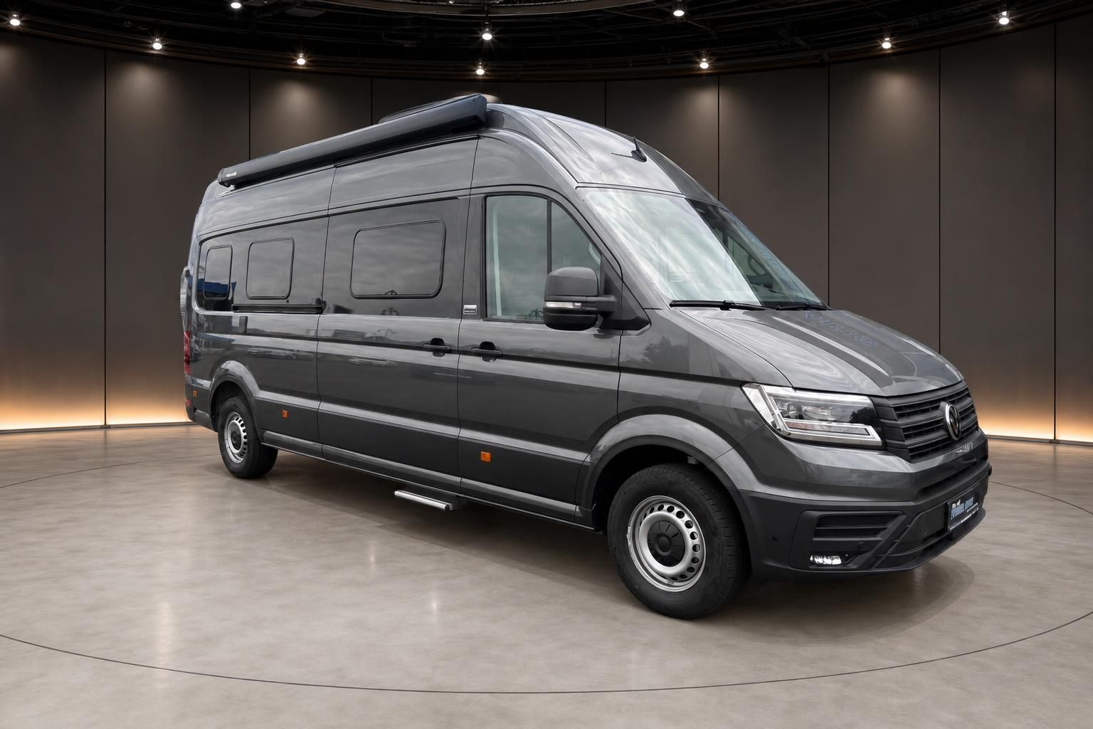 Volkswagen Crafter Wohnmobil in grau, Frontansicht schräg von links in Showroom-Beleuchtung
