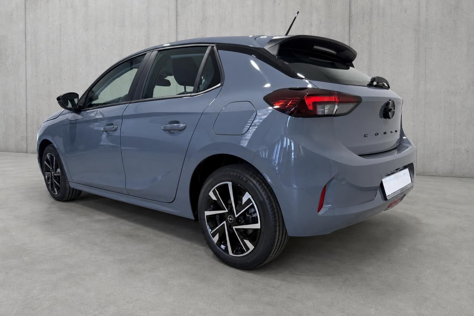 Opel Corsa Grau, Heckansicht von schraeg hinten links