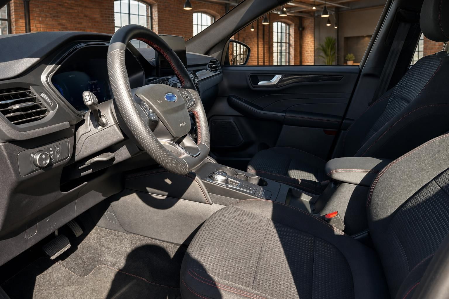 Ford Fahrerraum mit Sportlenkrad und schwarzen Sitzen mit roter Ziernaht