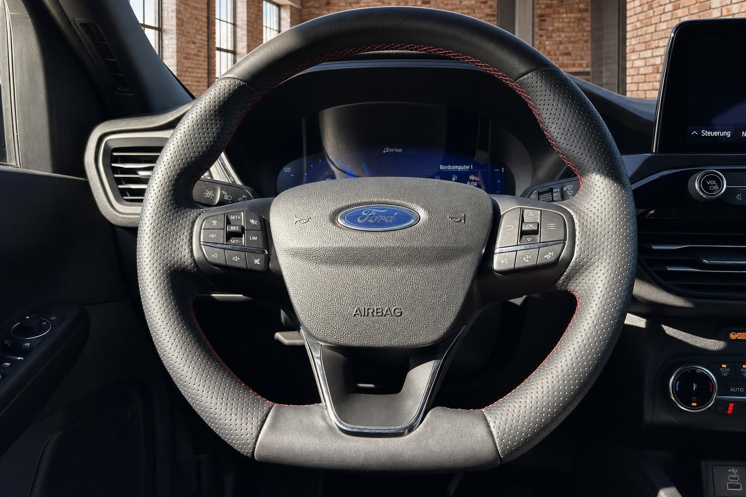 Ford Lenkrad Nahaufnahme mit Multifunktionstasten und Airbag-Emblem