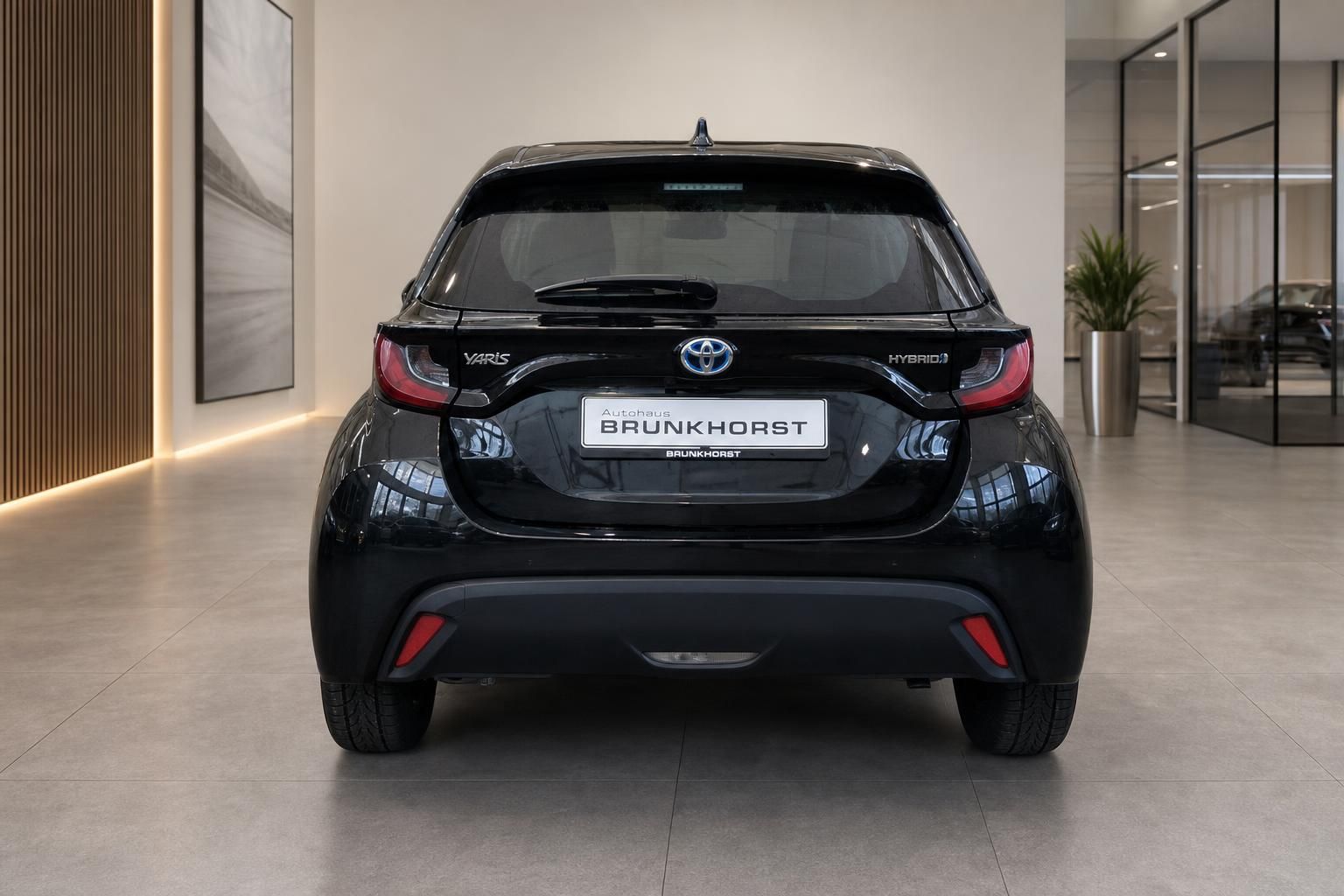 Toyota Yaris Hybrid schwarz Heckansicht im Showroom