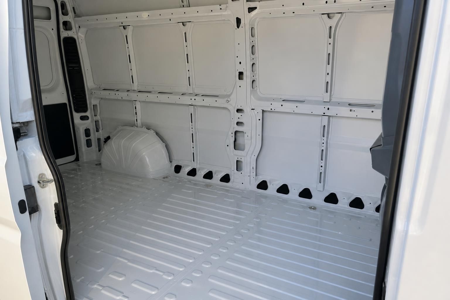 Leerer Laderaum eines weißen Transporters mit Riffelblech-Boden und Verzurrösen