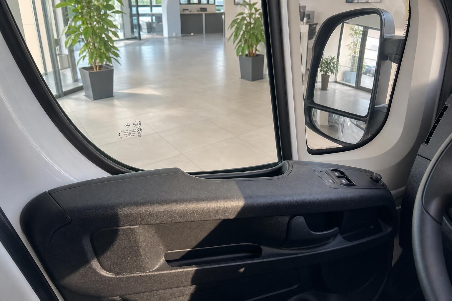 Fahrgastraum mit Fenstern, Außenspiegel und Türverkleidung im Transporter