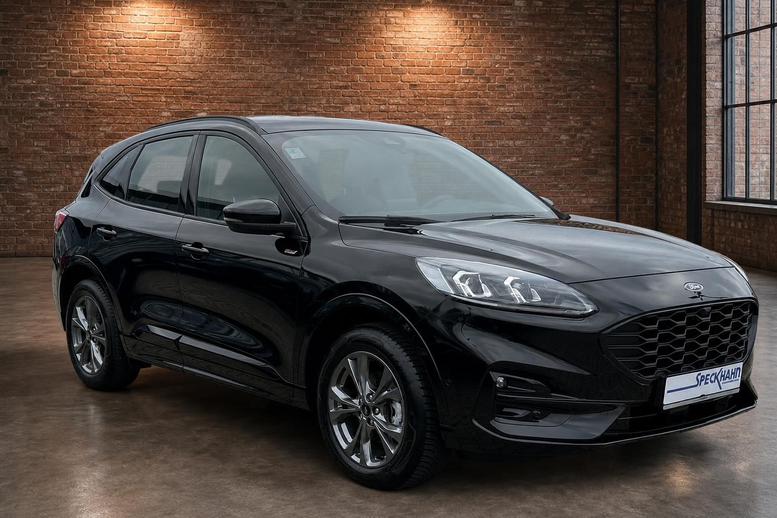 Ford Kuga schwarz Frontansicht seitlich vor Backsteinwand