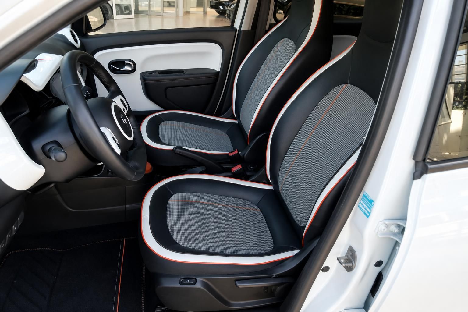 Renault Twingo Innenraum mit schwarz-weißen Sitzen und roten Akzenten