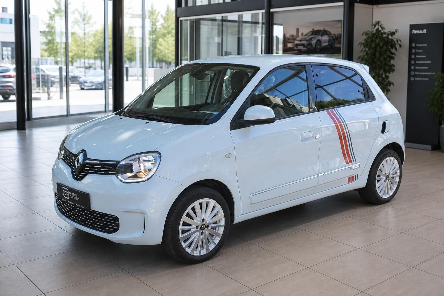 Renault Twingo weiss Dreiviertel-Frontansicht links im Autohaus Showroom mit Sportstreifen
