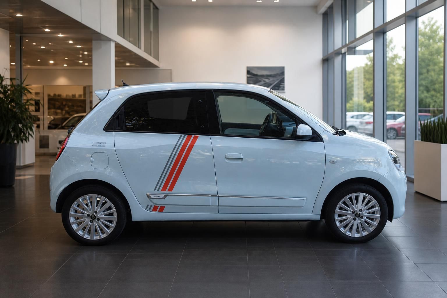 Renault Twingo Seitenansicht in hellblau mit Designstreifen im Autohaus