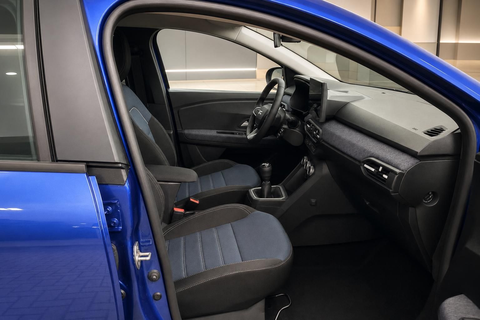 Dacia Innenraum mit blauen Sportsitzen und geoeffneter Fahrertuer